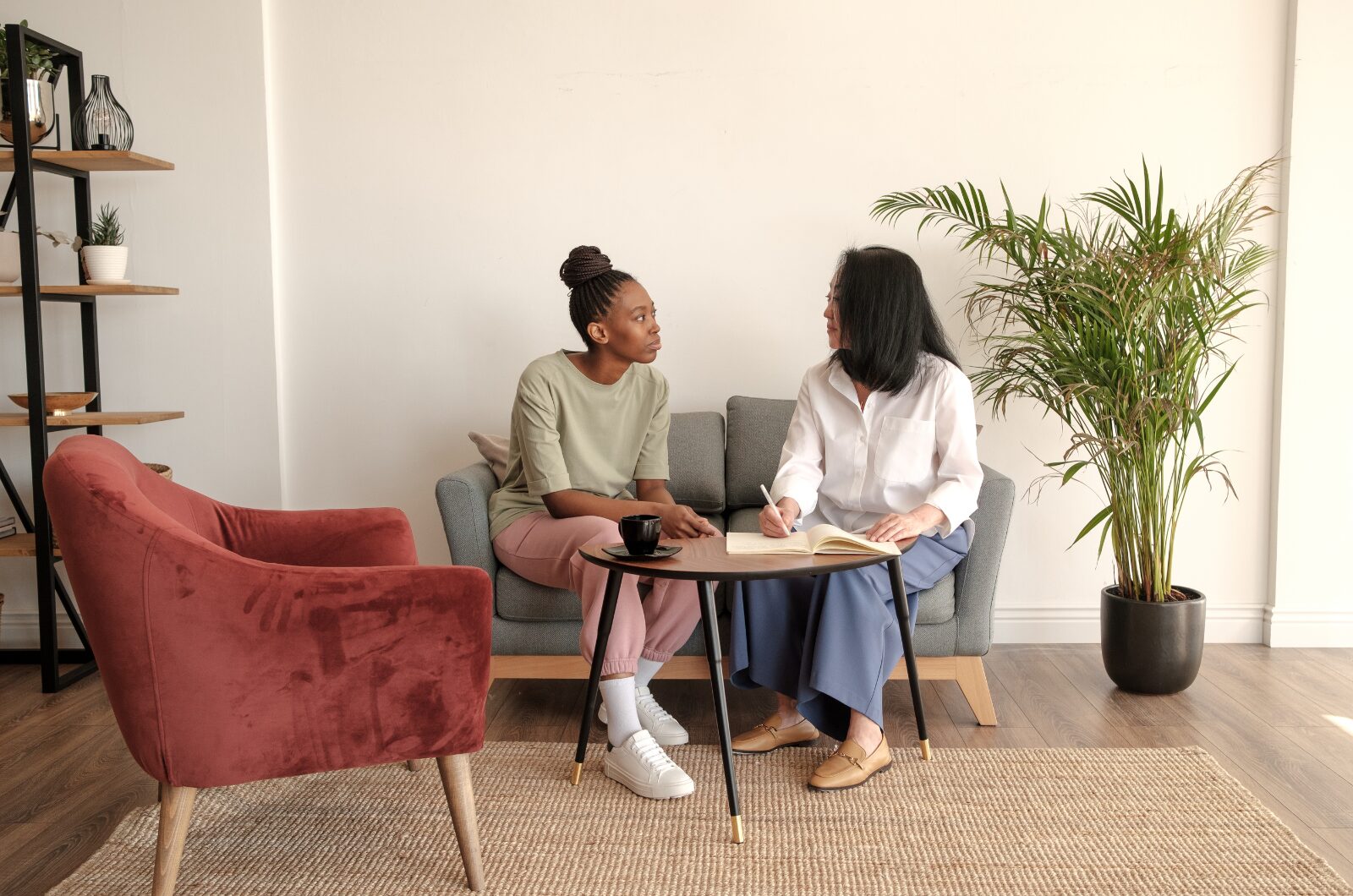 Therapist listening attentively to a woman during a trauma-informed counseling session in a calm, safe space