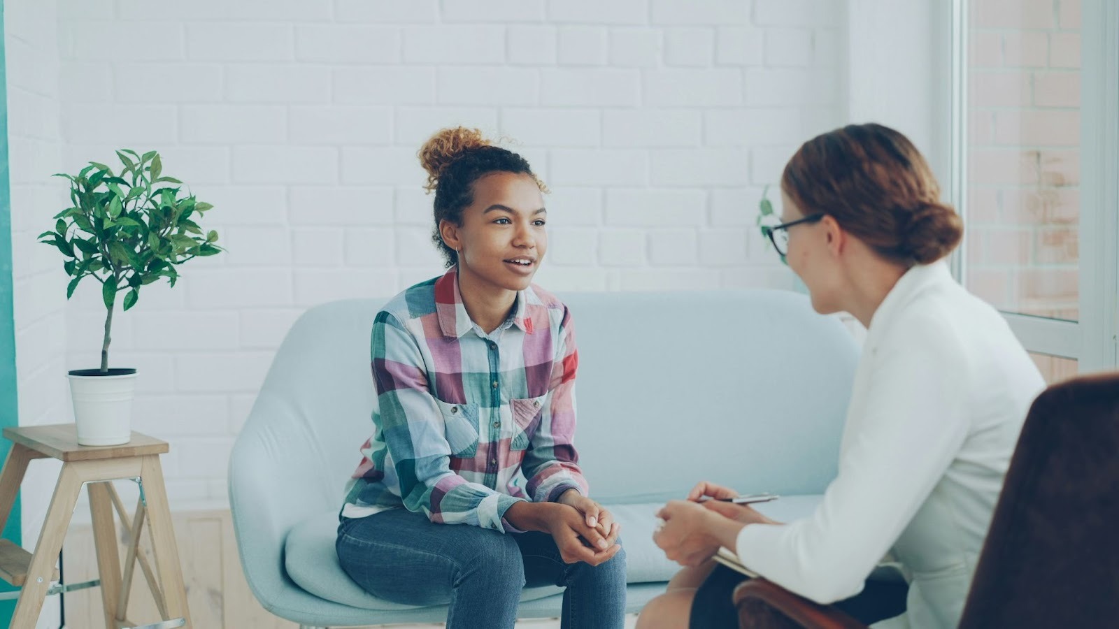 Young woman discussing childhood trauma with therapist during somatic therapy session in a supportive setting