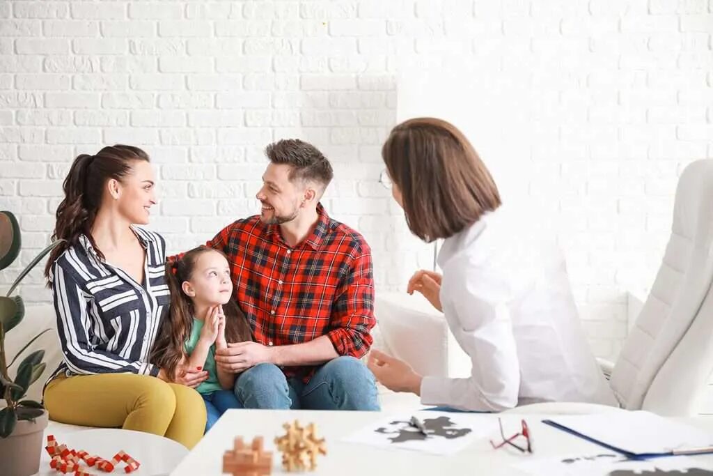 A happy family talking with a therapist during a family counseling session for San Diegans to strengthen relationships.