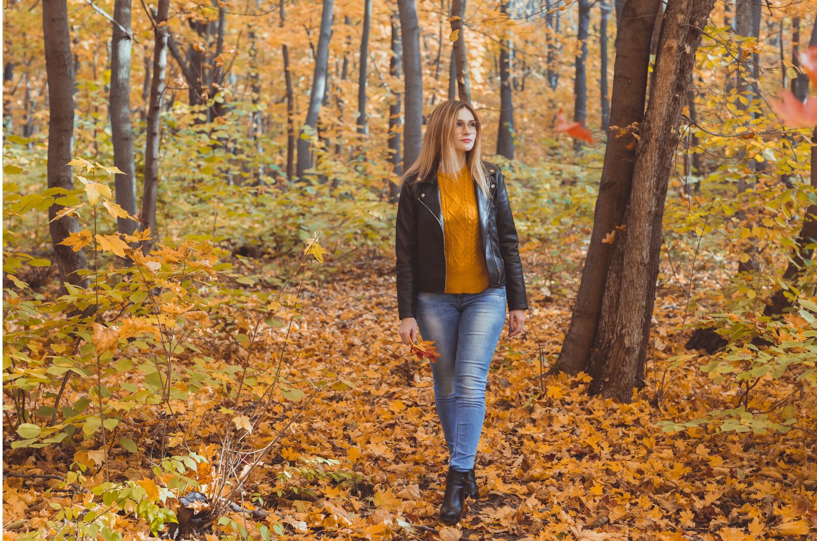 Coping with Seasonal Affective Disorder in San Diego: Causes, Symptoms, and Treatment Options A woman walking through a forest covered in autumn leaves, symbolizing change, reflection, and seasonal mood transitions.
