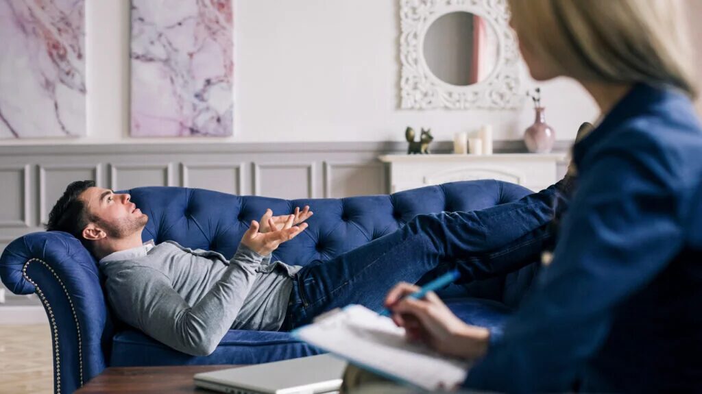 Adult client lying on a couch during a psychodynamic therapy session, exploring emotions and unconscious patterns