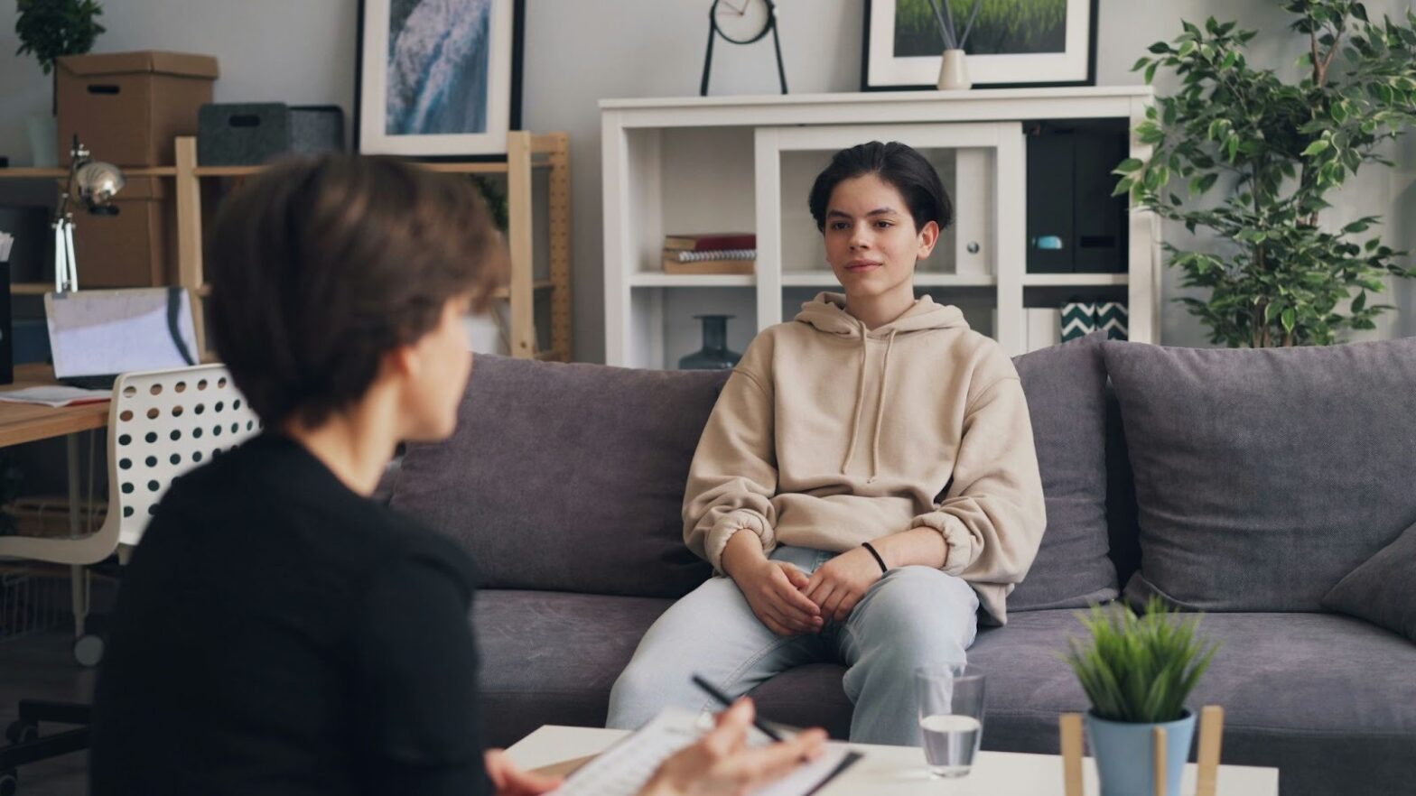 A teenager attends a cognitive behavioral therapy session, learning to manage emotions during life transitions